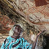 woman pointing to painting in cave