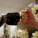 a human hand and robot hand fist-bumping